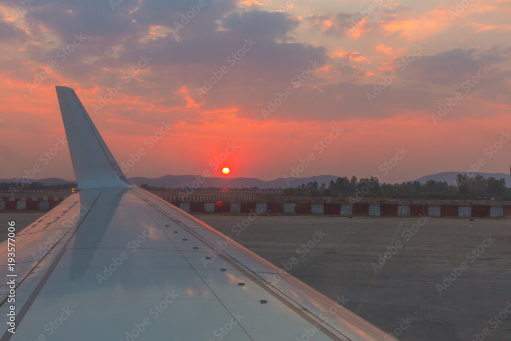 Naklejka premium Flugzeug Flügel im Sonnenuntergang