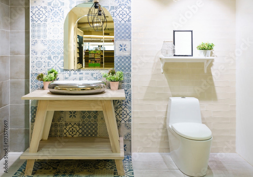 Modern spacious bathroom with bright tiles with toilet and sink. Side view