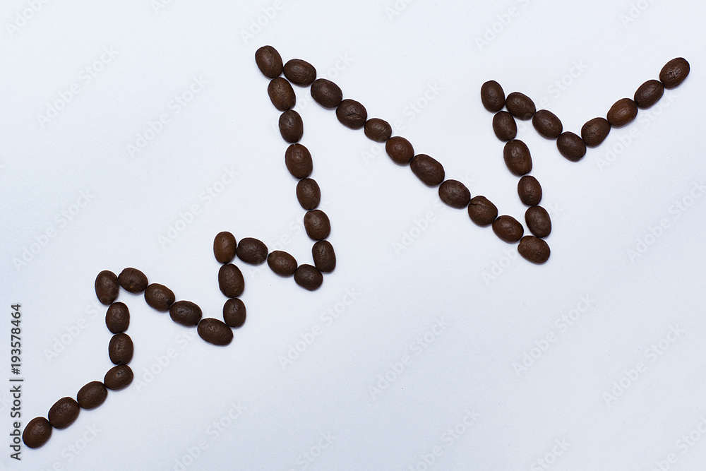 A line of electrocardiograms of roasted coffee beans on white background, heart rhythm ecg, medicine and health concept A line of electrocardiograms of roasted coffee beans on white background, heart rhythm ecg, medicine and health concept