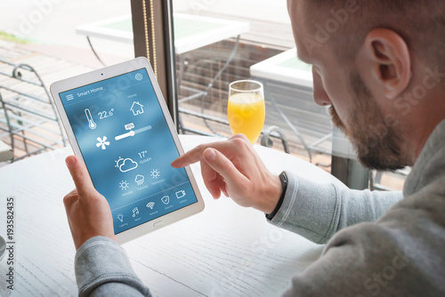Smart home control app on laptop display in man hands.