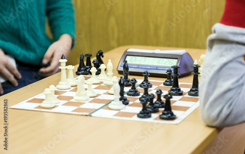 chessboard and chess watch lie on the desk at school tournament