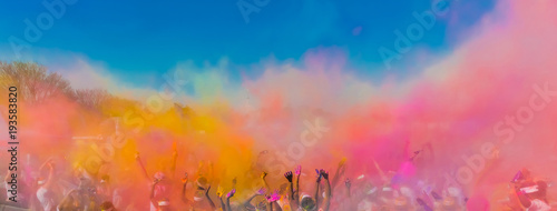 Crowd throwing bright coloured powder paint in the air, Holi Festival Dahan