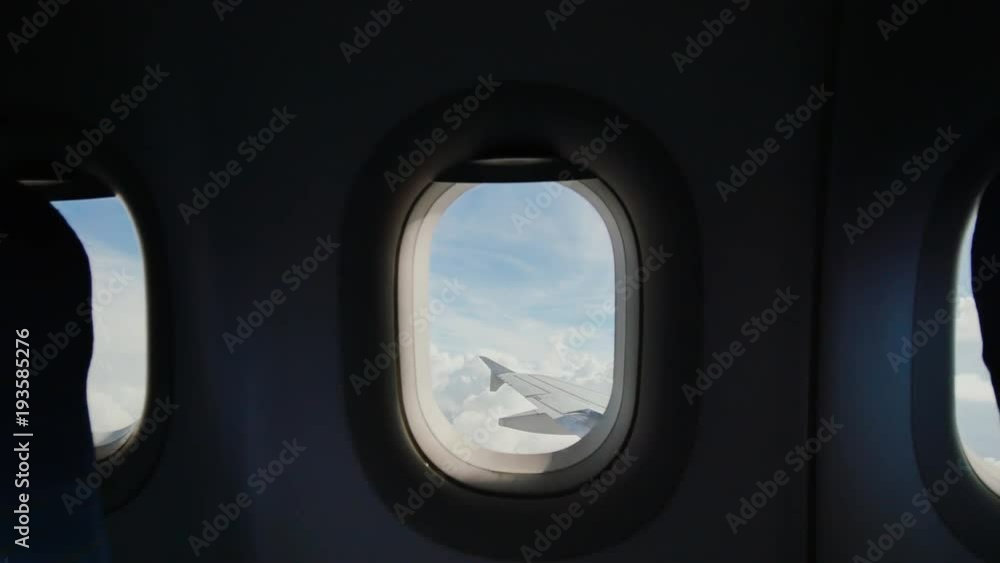 Looking out the window of an airplane as clouds pass by. Looking out the window of an airplane as clouds pass by.