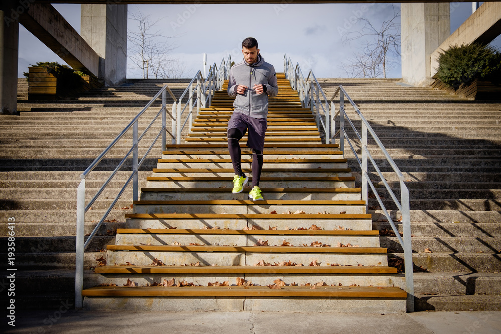 Young athlete man runs up and down the stairs