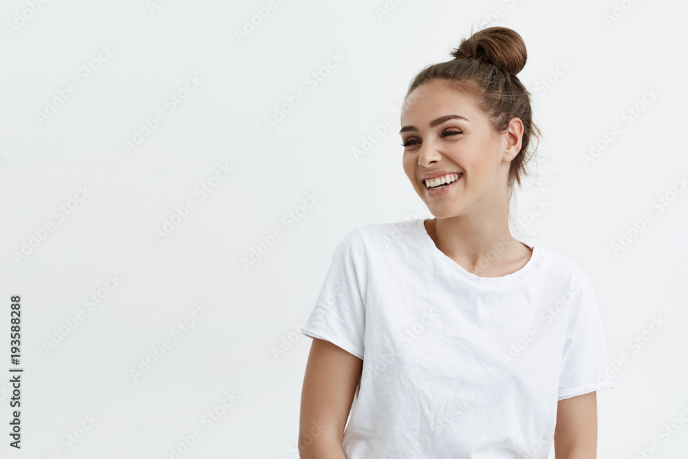Portrait of emotive good-looking caucasian woman laughing while looking aside and standing against white background. Positive housewife on shopping with kids. Fashionable girl talks with friends Portrait of emotive good-looking caucasian woman laughing while looking aside and standing against white background. Positive housewife on shopping with kids. Fashionable girl talks with friends