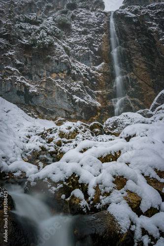 Huge waterfall in winter covered in snow.