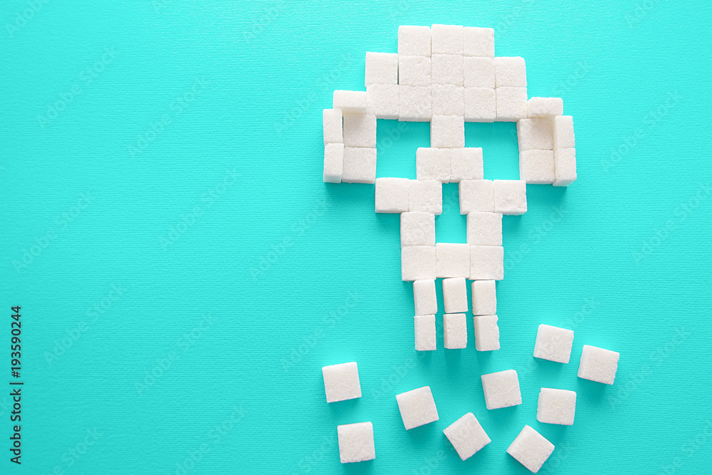 Fototapeta premium The skull made of sugar cubes. Sugar kills. Green background.