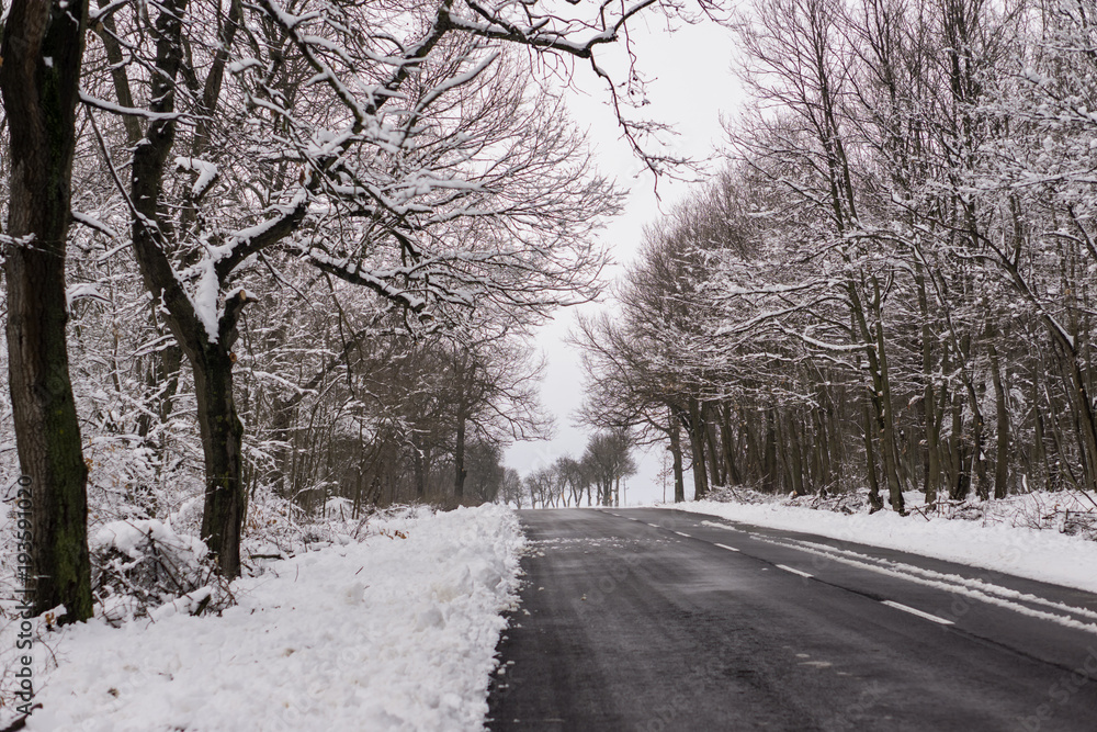 Winter driving problems, snow and ice. Extreme winter series. Close up of a road in cold winter conditions, a road cleared from the snow. Winter driving problems, snow and ice. Extreme winter series. Close up of a road in cold winter conditions, a road cleared from the snow.