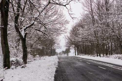 Winter driving problems, snow and ice. Extreme winter series.  Close up of a  road in cold winter conditions, a road cleared from the snow.