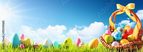 Easter Eggs in a Basket on Green Grass and Blue Sunny Sky