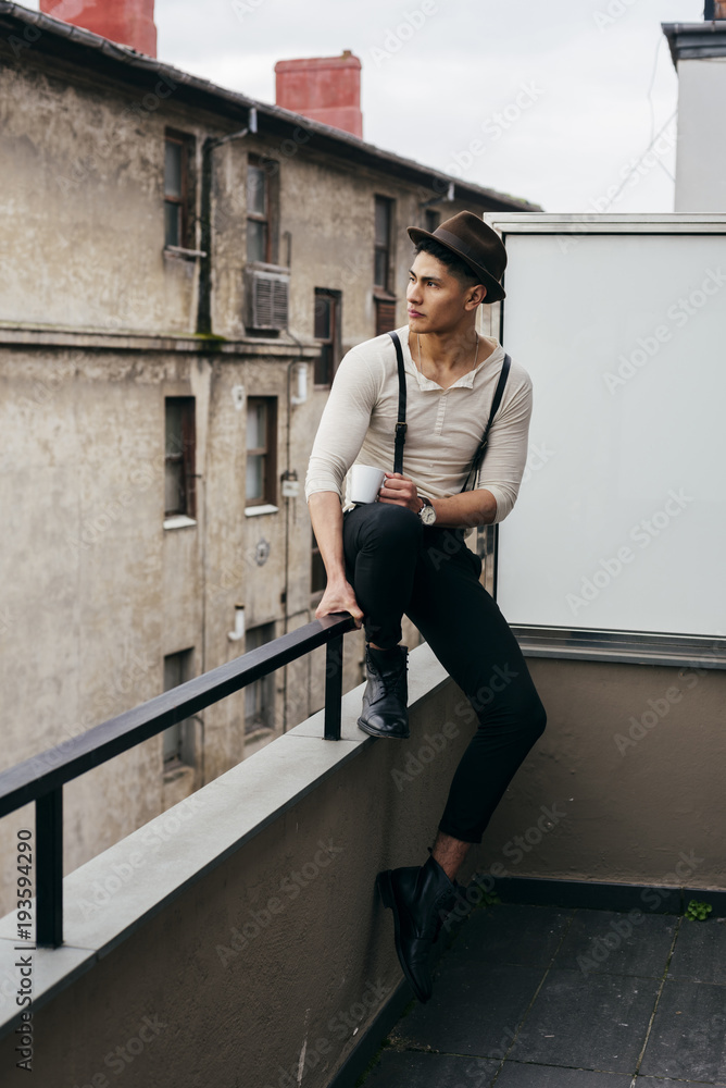 Stylish man with cup on balcony Stylish man with cup on balcony