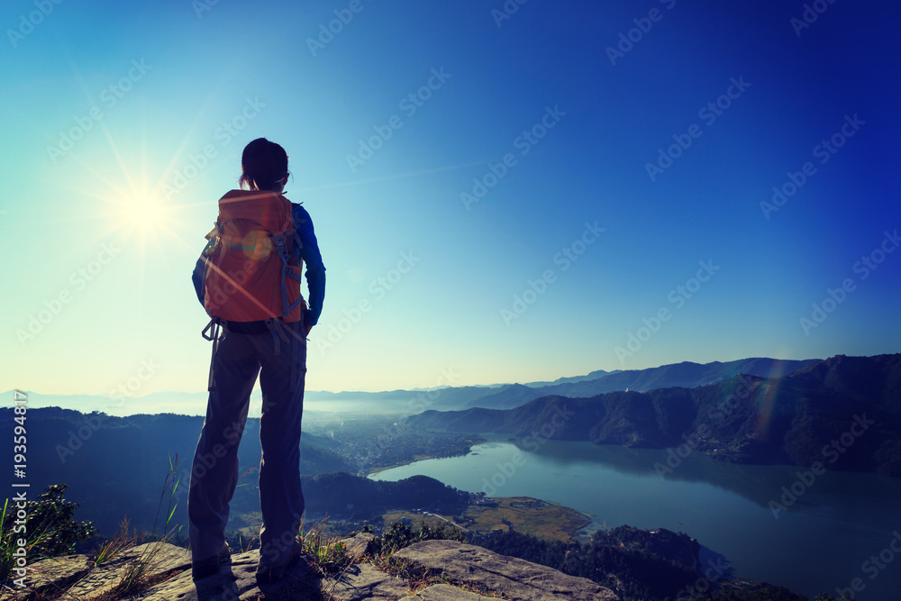 successful woman hiker enjoying the sunrise in the himalaya mountains