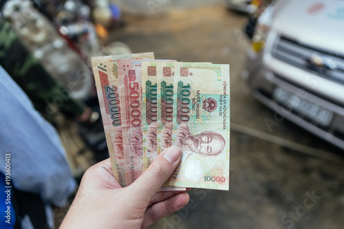 Vietnamese banknotes in left hand waiting for pay in Sa Pa, Vietnam. photo