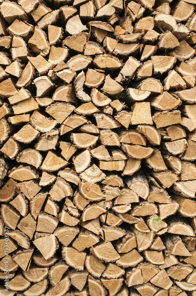 Stacked cut oak firewood closeup as background Stacked cut oak firewood closeup as background