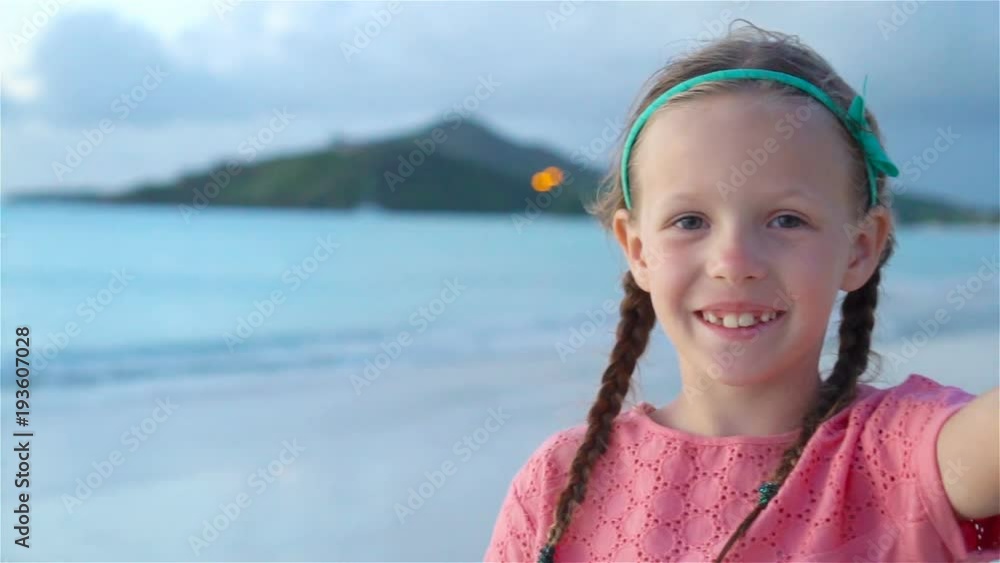 Adorable little girl taking selfie at tropical white beach. SLOW MOTION Adorable little girl taking selfie at tropical white beach. SLOW MOTION