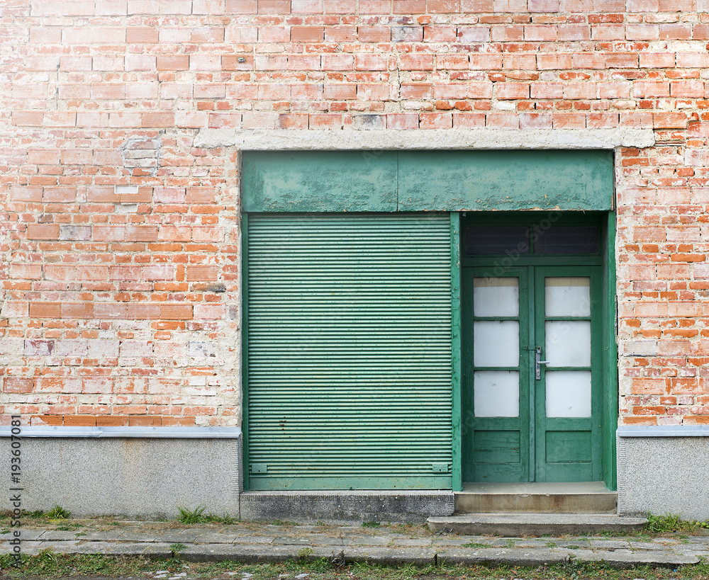 Old abondoned shop with green metal roller shutter. Closed business Old abondoned shop with green metal roller shutter. Closed business