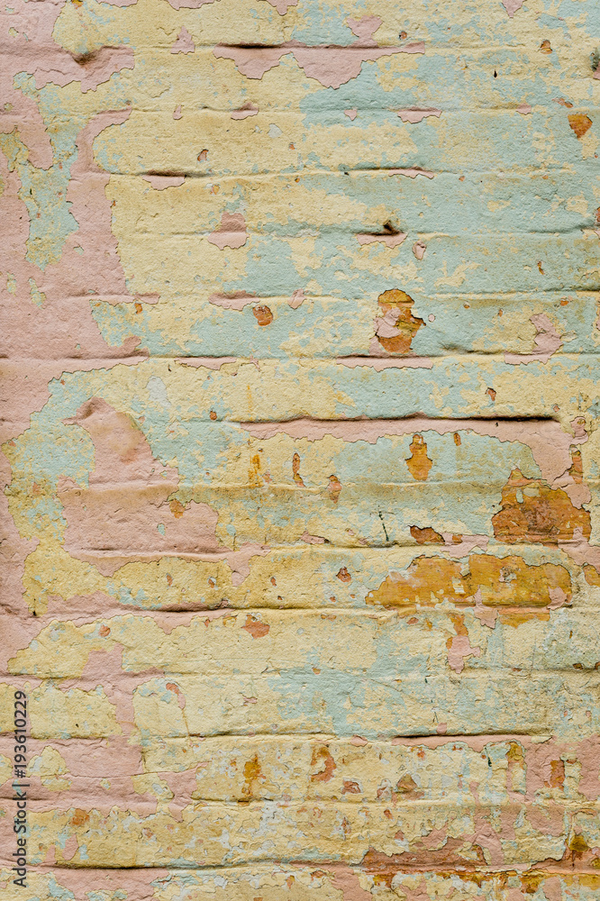 Fototapeta premium Textured background of multi-layer flaking paint on the wall. Mixing different colors of paints in the cleaved layers on the surface. Grunge texture with a deep pattern