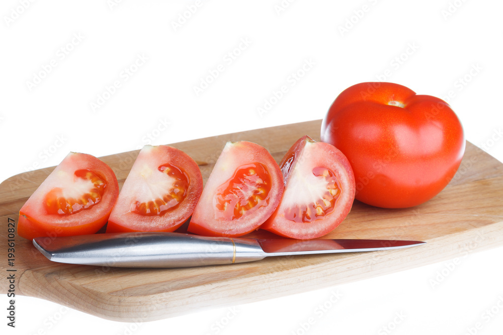 Tomatoes on the wooden cutting board cut into slices Tomatoes on the wooden cutting board cut into slices