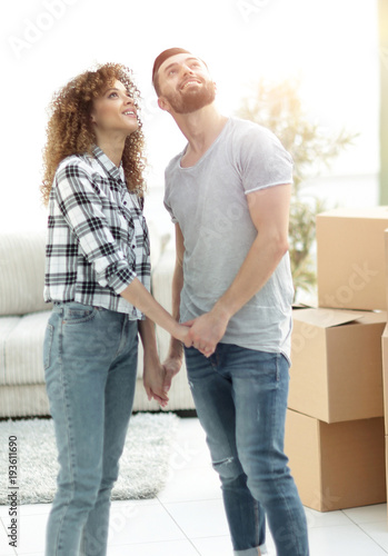 Young couple standing in new apartment and looking up © ASDF