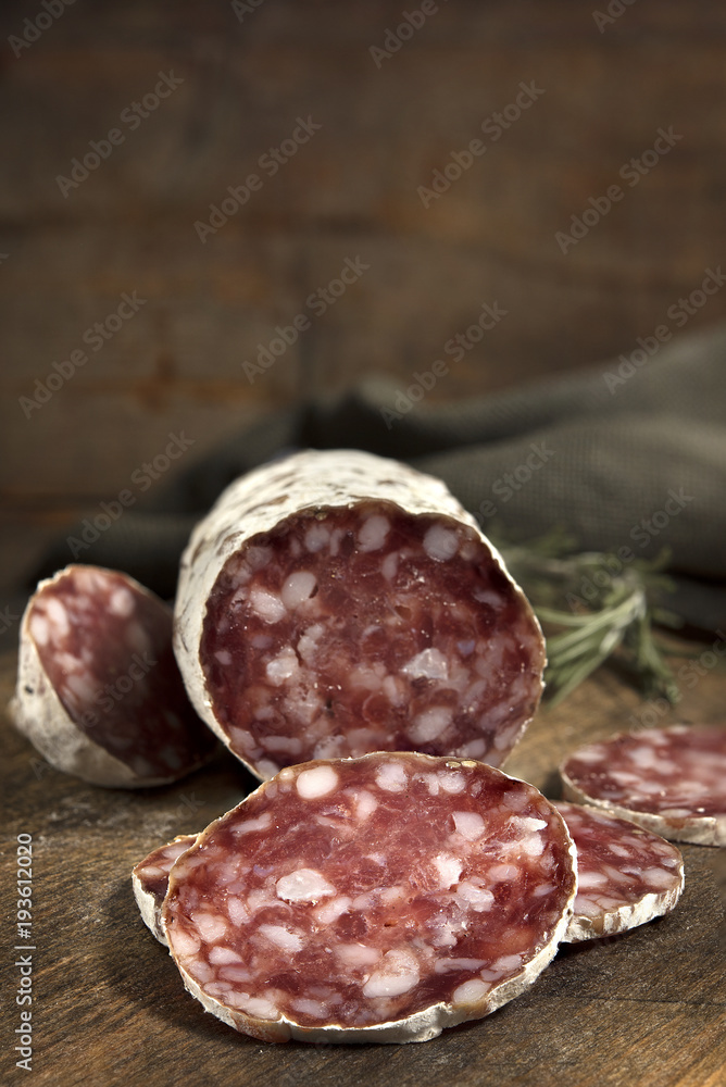 Salami slices on the wooden table. Spicy and tasty. Salami slices on the wooden table. Spicy and tasty.