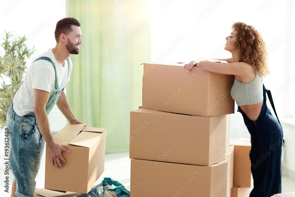 young couple unpacking boxes in a new house young couple unpacking boxes in a new house
