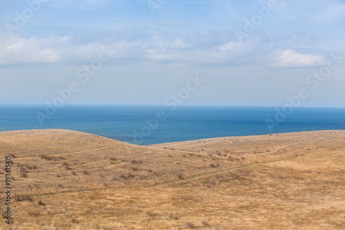 Hilly seashore and a blue surface of the sea.