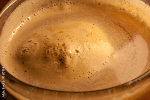 Cappuccino coffee in a glass. Texture of orange foam.