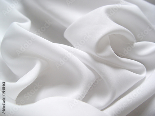 White satin fabric draped in soft waves photo