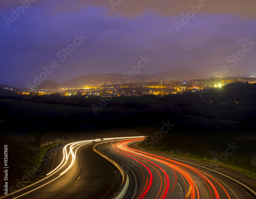 Car lights going to the city at night © poliki