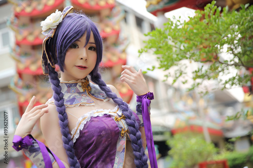 Portrait of asian young woman dancing with purple Chinese dress cosplay with temple photo
