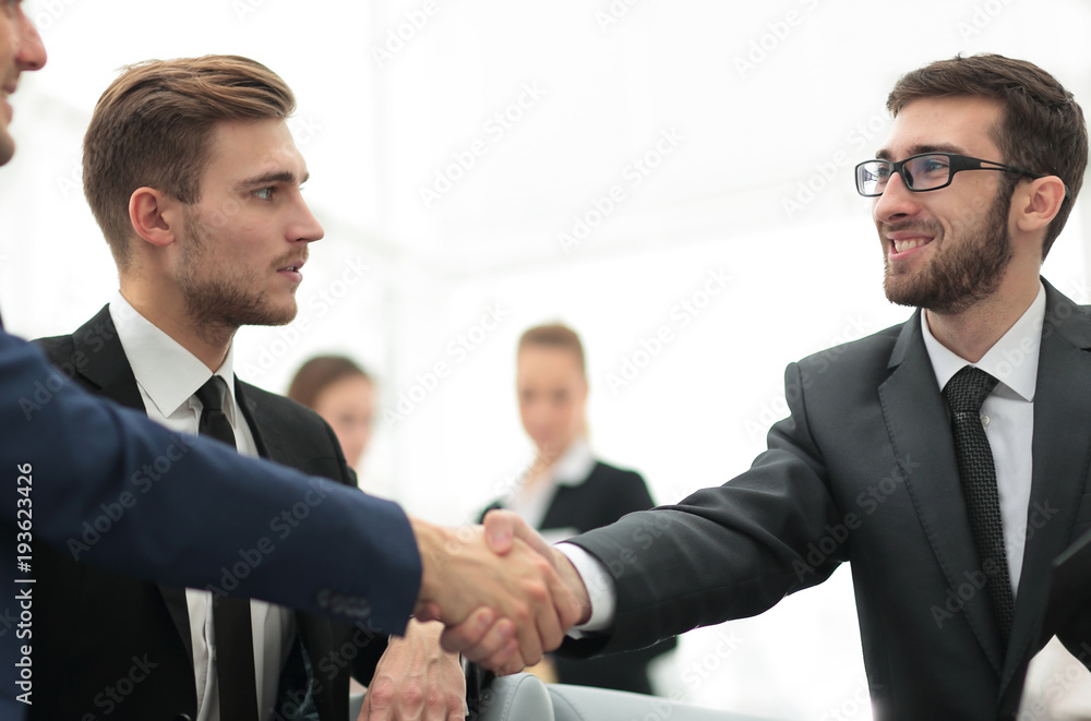 Partners concluding deal and shaking hands in the presence of team members Partners concluding deal and shaking hands in the presence of team members