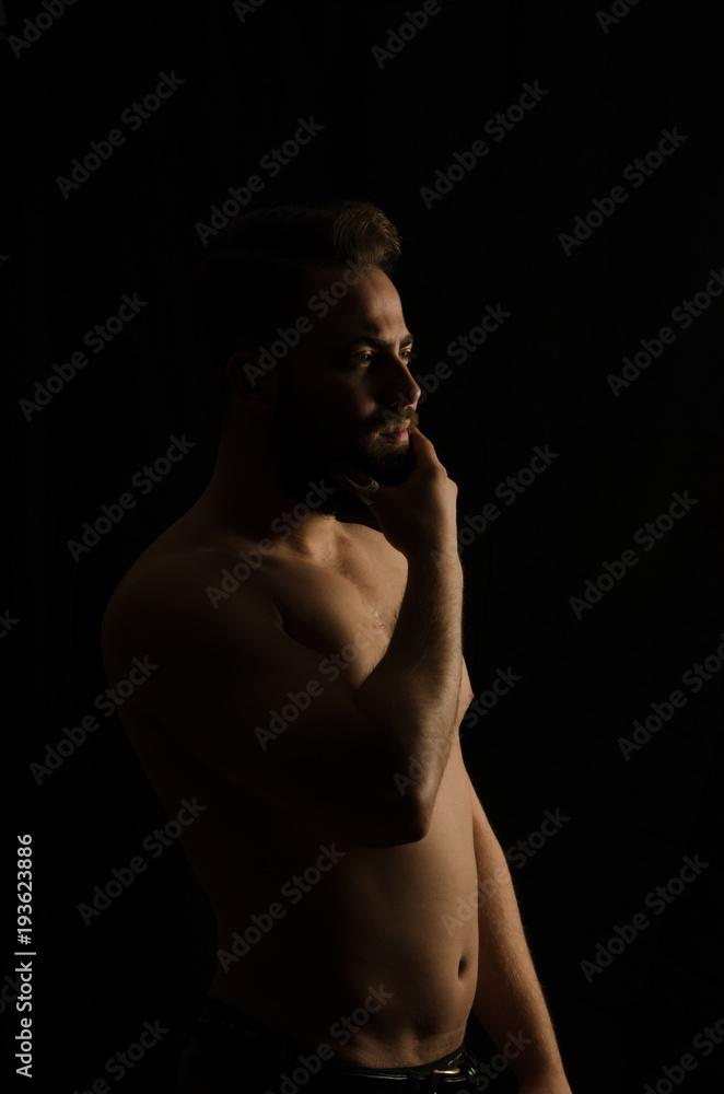 shirtless, handsome young man standing. Studio shot of light, shirtless, handsome young man standing. Studio shot of light,