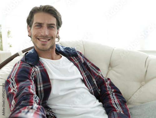 confident guy sitting in a chair and holding out his hand.