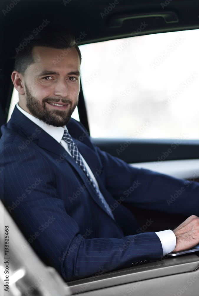 Close-up of a businessman with a laptop sitting in the car Close-up of a businessman with a laptop sitting in the car