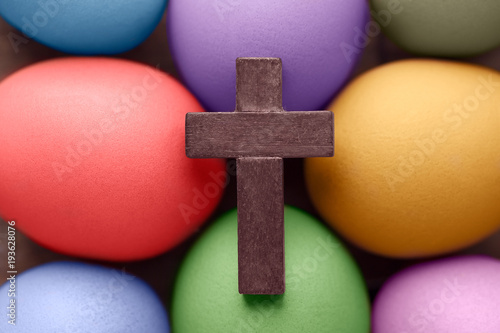 Wooden cross above the colored Easter eggs
