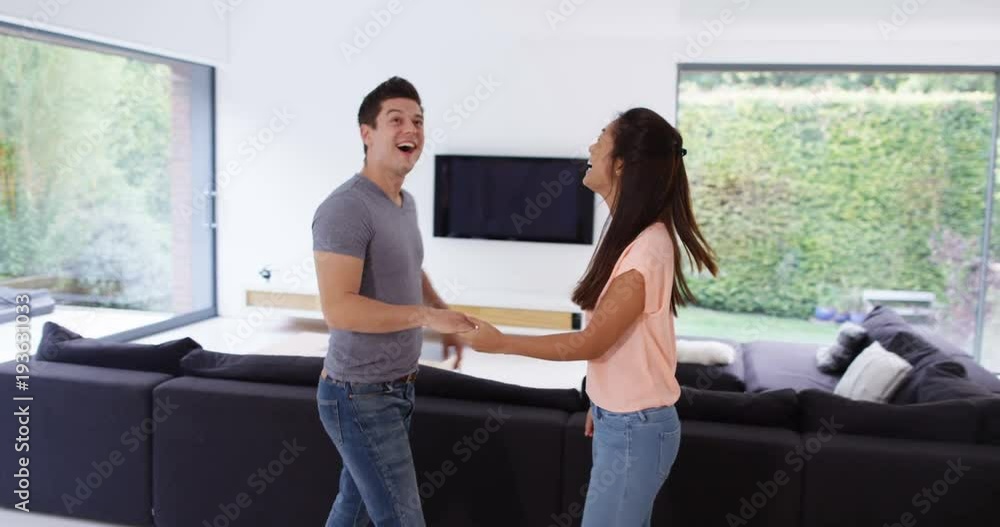 4K Very happy excited young couple looking around their first home together 4K Very happy excited young couple looking around their first home together