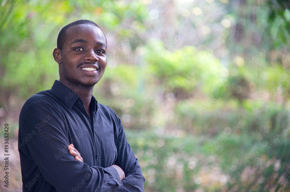 African business man looking and smiling in green nature background. African business man looking and smiling in green nature background.