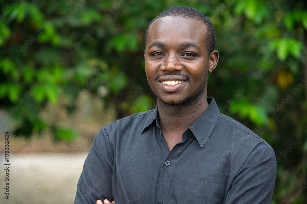 African business man looking and smiling in green nature background. African business man looking and smiling in green nature background.
