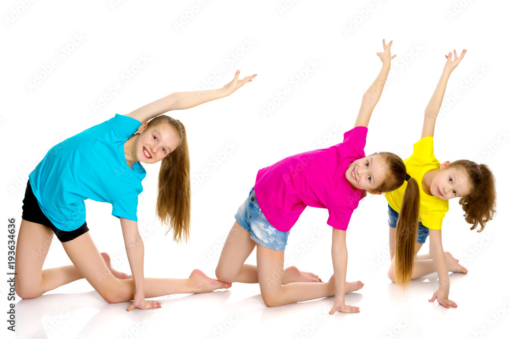 A group of girls gymnasts perform exercises. A group of girls gymnasts perform exercises.