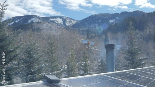 Smoke from cabin chimmney near solar panels.  photo