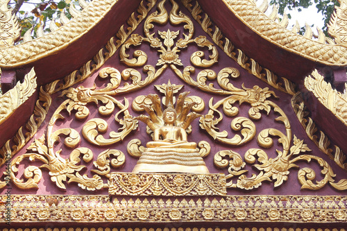  Gold gable temple stucco roof with buddha Sheltered by Naga Hood patterns on background
