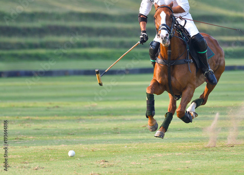 The polo player is riding on a horse