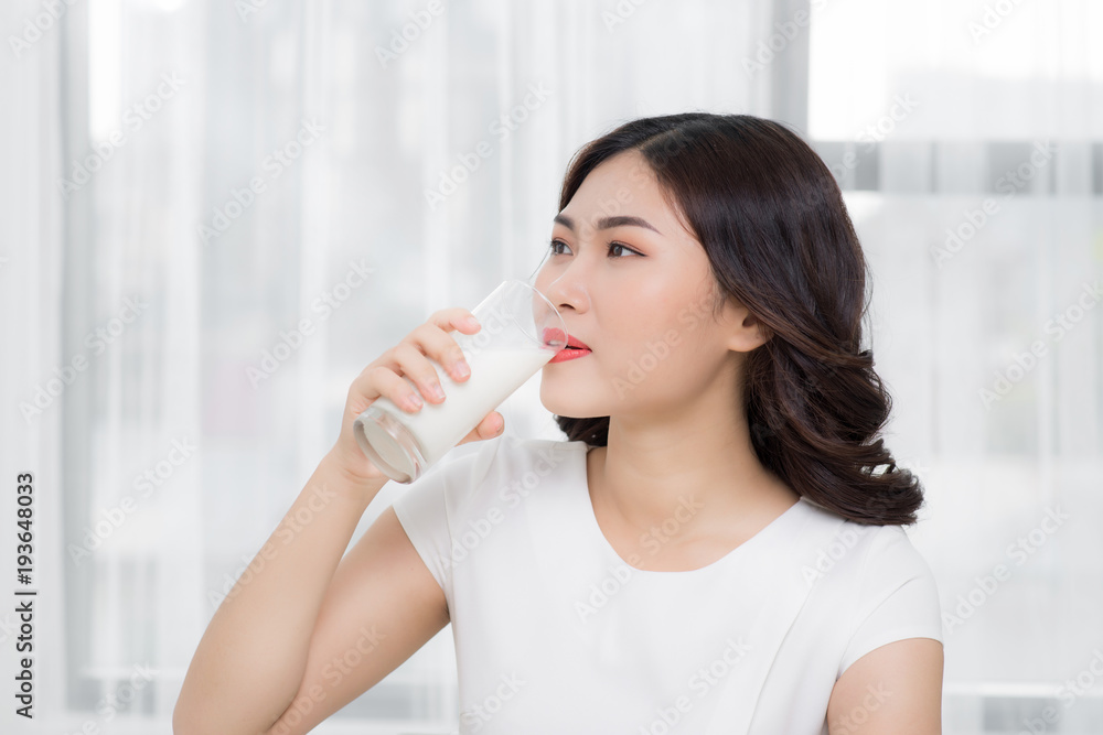 Beautiful asian girl drinking a glass of milk. Beautiful asian girl drinking a glass of milk.