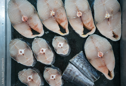 Fotografia some slices of fresh raw fish on a black background