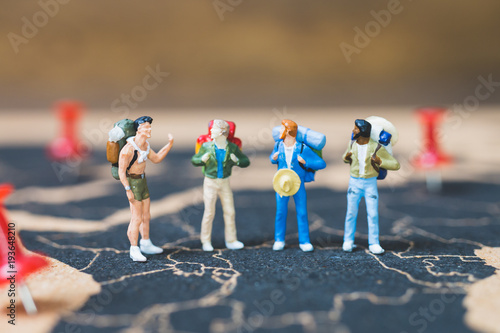 Miniature people backpacker walking on world map, Tourism and travel concept