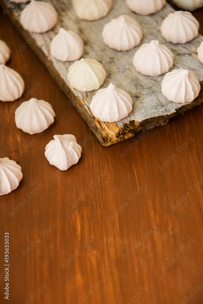 lots of little meringues on dark wooden background lots of little meringues on dark wooden background