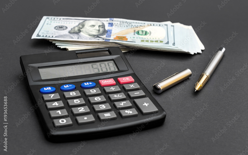 Calculator with dollar bills and pen on black. Calculator with dollar bills and pen on black.