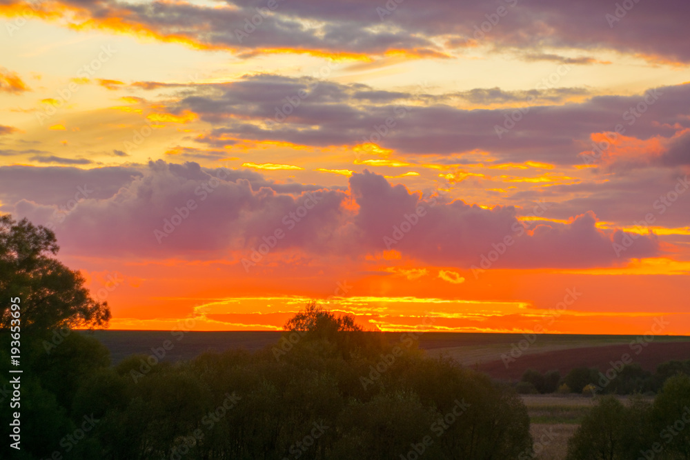 Natural Sunset Sunrise Over Field Or Meadow. Bright Dramatic Sky And Dark Ground. Countryside Landscape Under Scenic Colorful Sky At Sunset Dawn Sunrise. Sun Over Skyline, Horizon. Warm Colours. Natural Sunset Sunrise Over Field Or Meadow. Bright Dramatic Sky And Dark Ground. Countryside Landscape Under Scenic Colorful Sky At Sunset Dawn Sunrise. Sun Over Skyline, Horizon. Warm Colours.