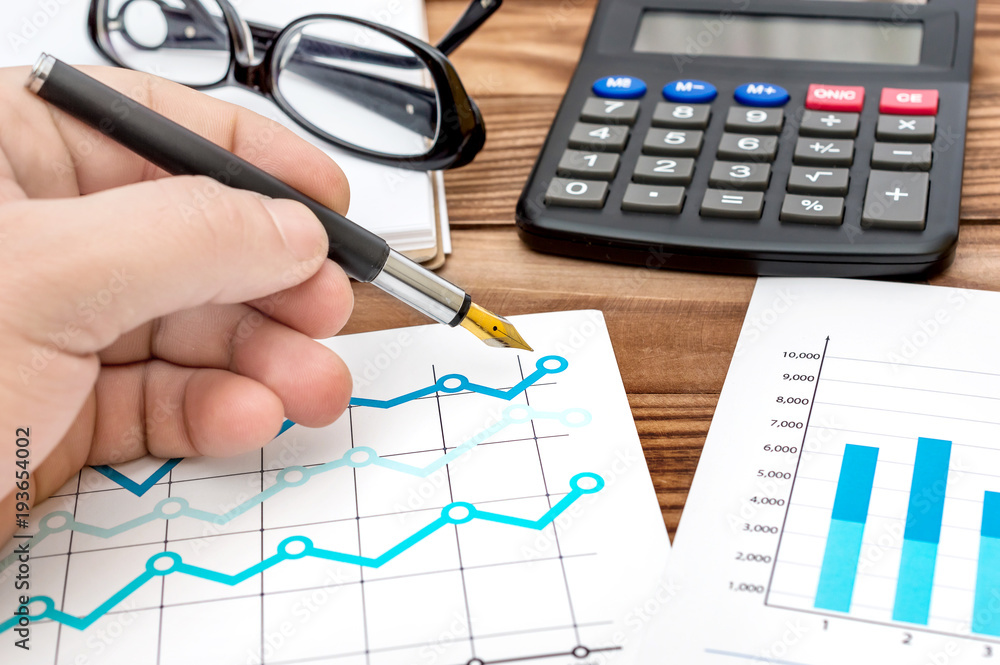 Businessman working with financial documents at his workplace. Close up. Business concept. Businessman working with financial documents at his workplace. Close up. Business concept.