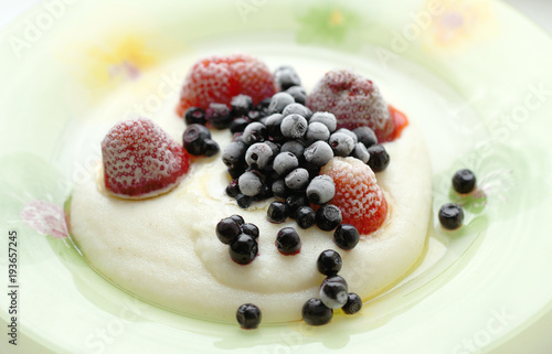 Manna porridge with frozen berries close-up. Food for children with blueberries and strawberries for breakfast.